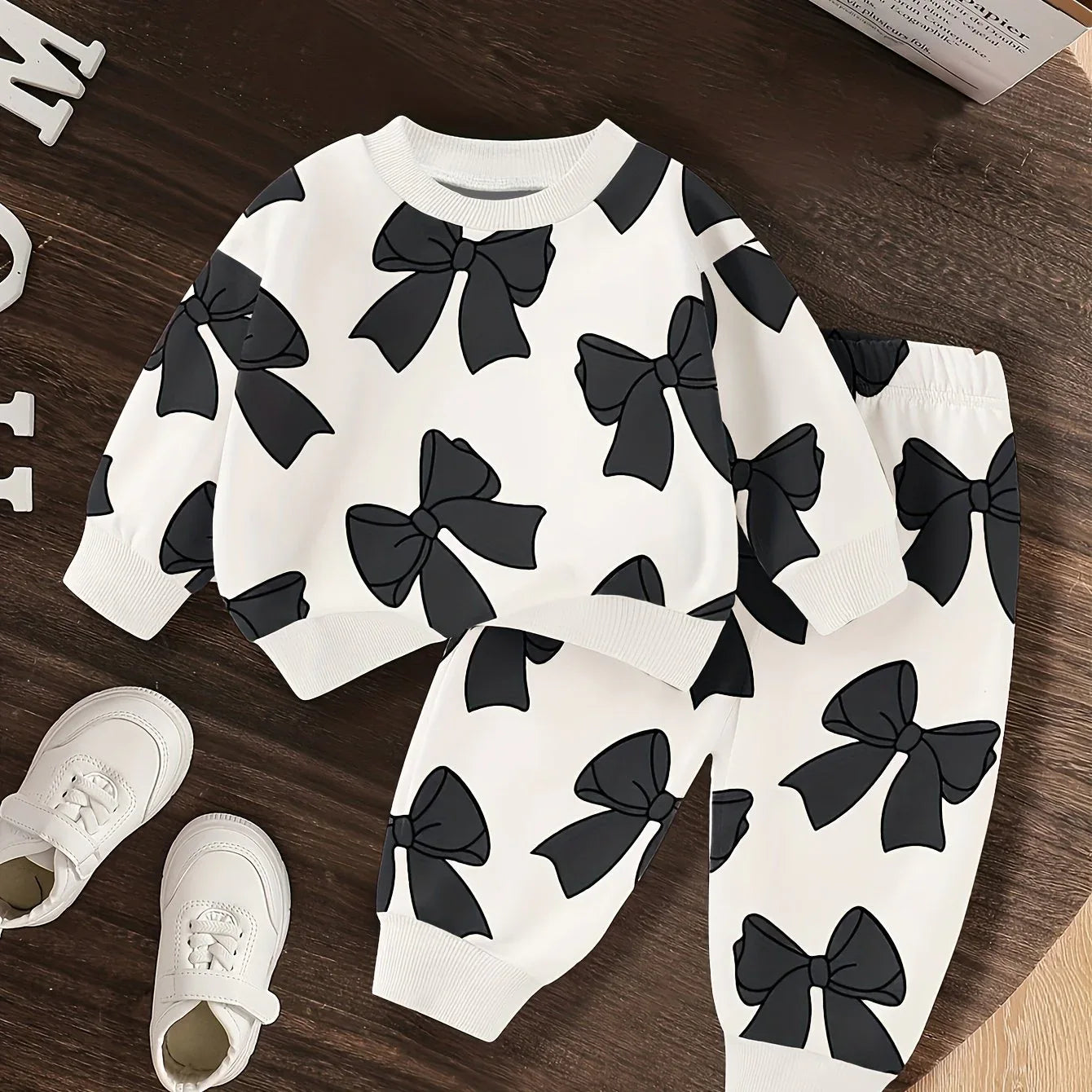 A Cute Cartoon Long-Sleeve Top with a Bow Pattern And Matching Long Pants Set for Baby Girls, Perfect for Outdoor Wear. - alotasawkli