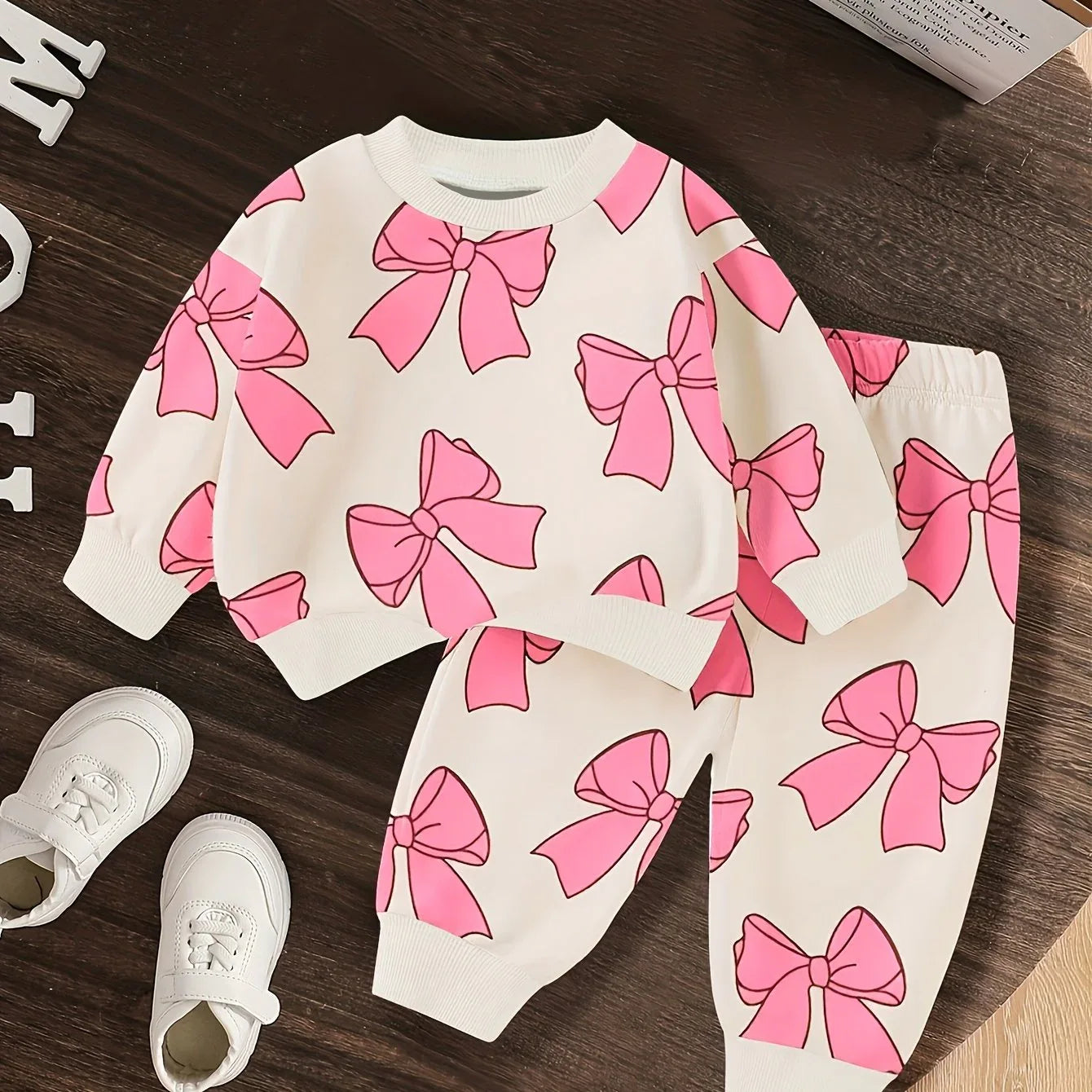A Cute Cartoon Long-Sleeve Top with a Bow Pattern And Matching Long Pants Set for Baby Girls, Perfect for Outdoor Wear. - alotasawkli